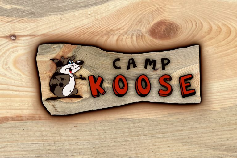 Logo Camp Koose - Originalschild ist aus waldeigenem Kiefernholz handgeschnitzt und gefräst - hängt am Eingang